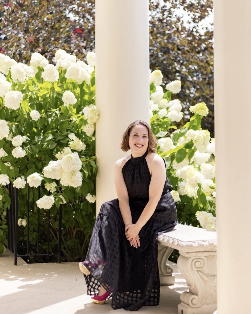 Francesca Merritt seated in a garden portico, wearing a black gown